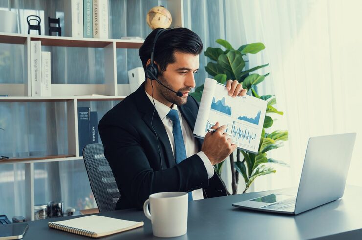 man-wearing-headset-sits-desk-front-laptop-with-laptop-mug-coffee_31965-138590